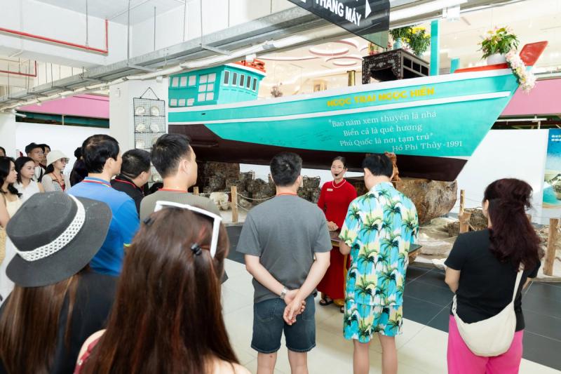 Visitors looking at an indoor boat display in the pearl collection