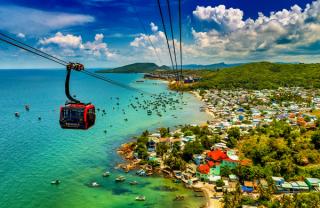Cable-car cabins above a coastal village and harbour