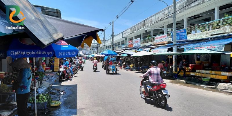 A street through Duong Dong market with stalls and passing motorcycles