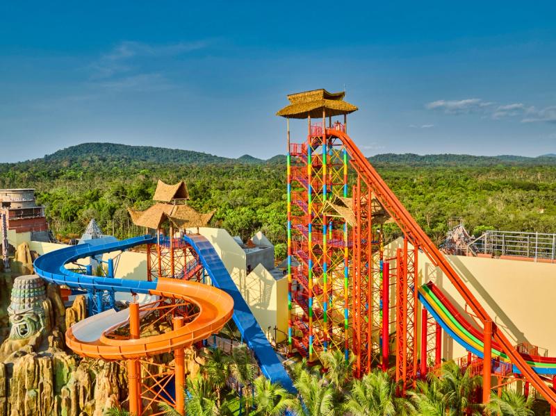 Tall straight water slides beside blue and orange curved slides