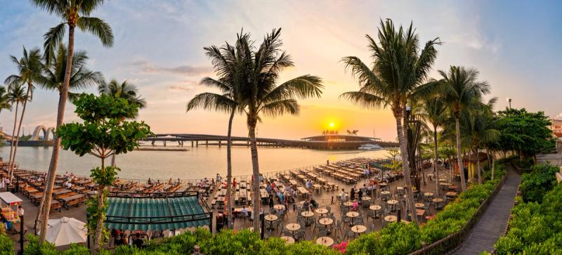 Palm trees and the Sun Bavaria waterfront dining area at sunset