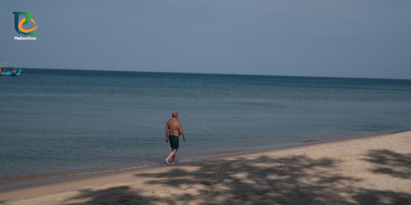A person walking along the Long Beach shoreline