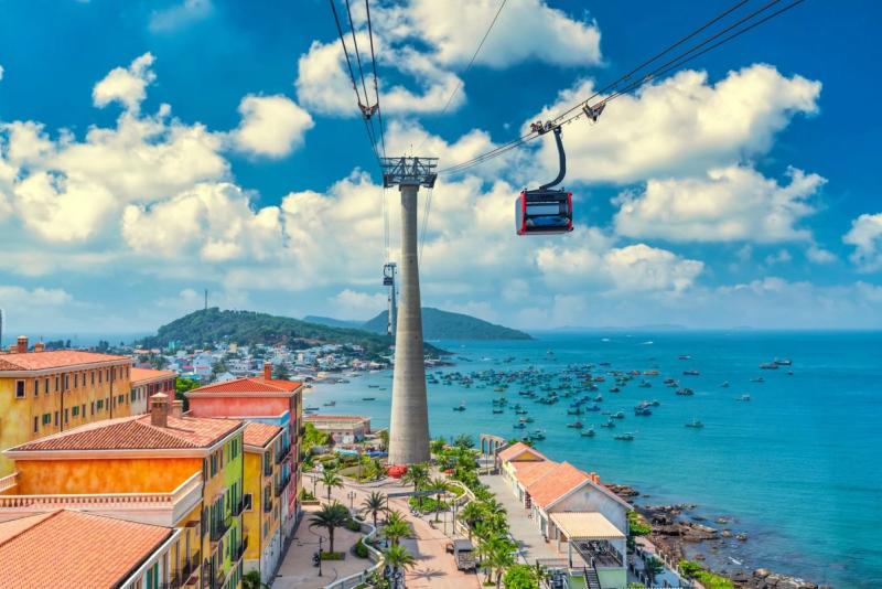 Cable-car cabin above An Thoi rooftops and harbor