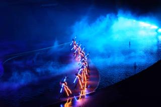 A line of performers on the blue-lit Kiss of the Sea stage