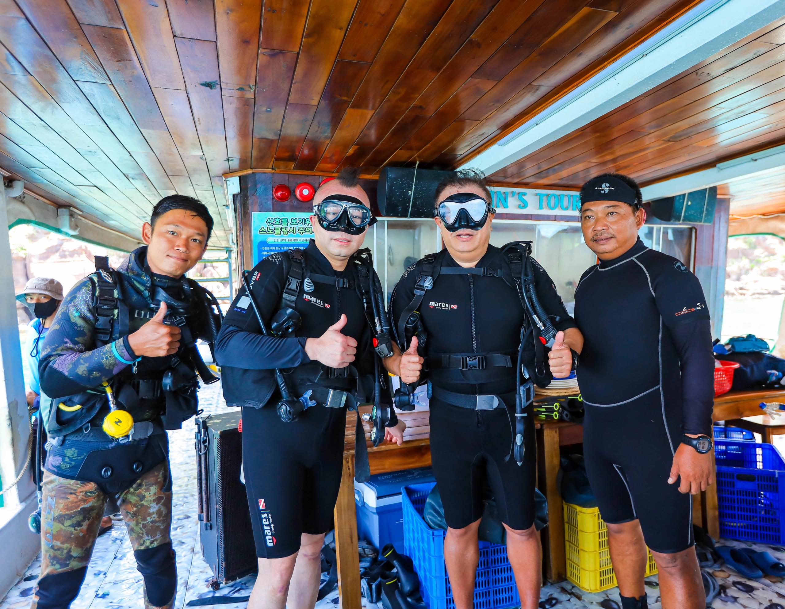 Divers wearing scuba equipment aboard a boat