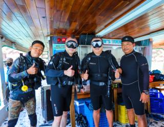Divers wearing scuba equipment aboard a boat