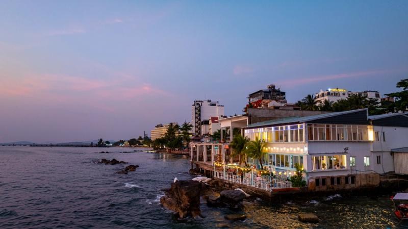 The Waterfront building beside coastal rocks at dusk