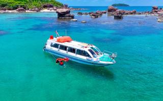 A speedboat beside a rocky island in turquoise water