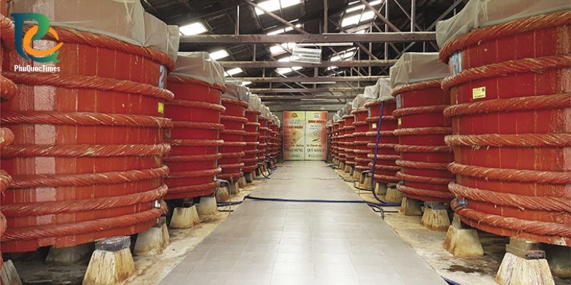 Rows of wooden fermentation barrels inside the Khai Hoan fish-sauce house