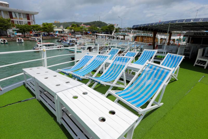 Blue-and-white loungers on the open upper deck of a tour boat