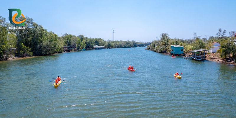 Kayaks on the Cua Can River between wooded banks