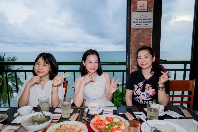 Three diners at a sea-facing table at Xin Chao