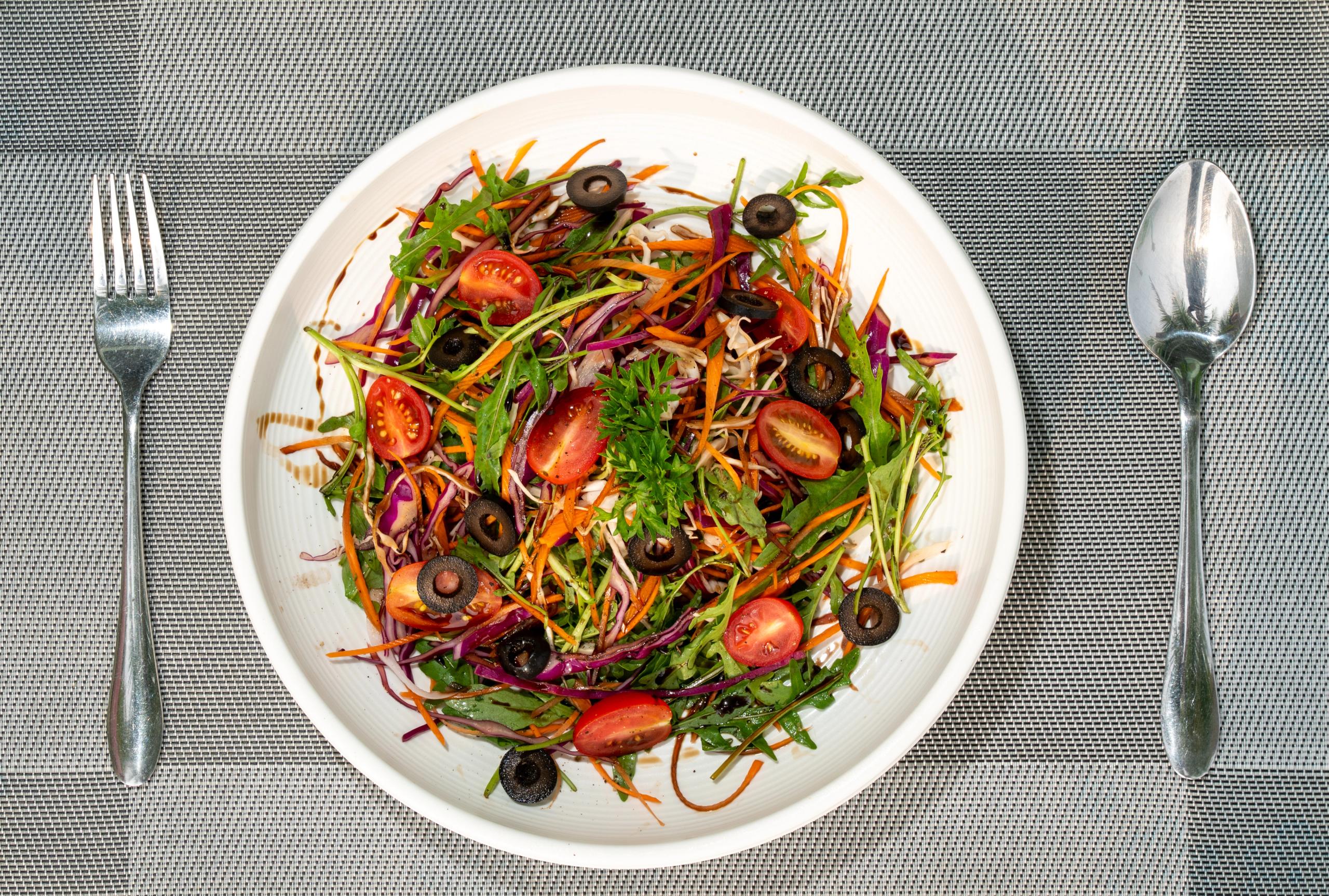 A colourful salad with leafy greens and tomatoes