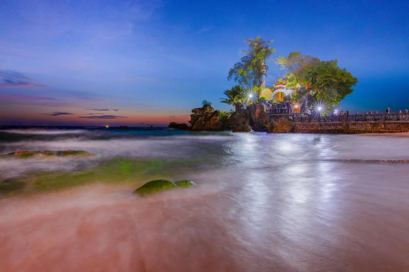 Dinh Cau illuminated beside the sea at dusk