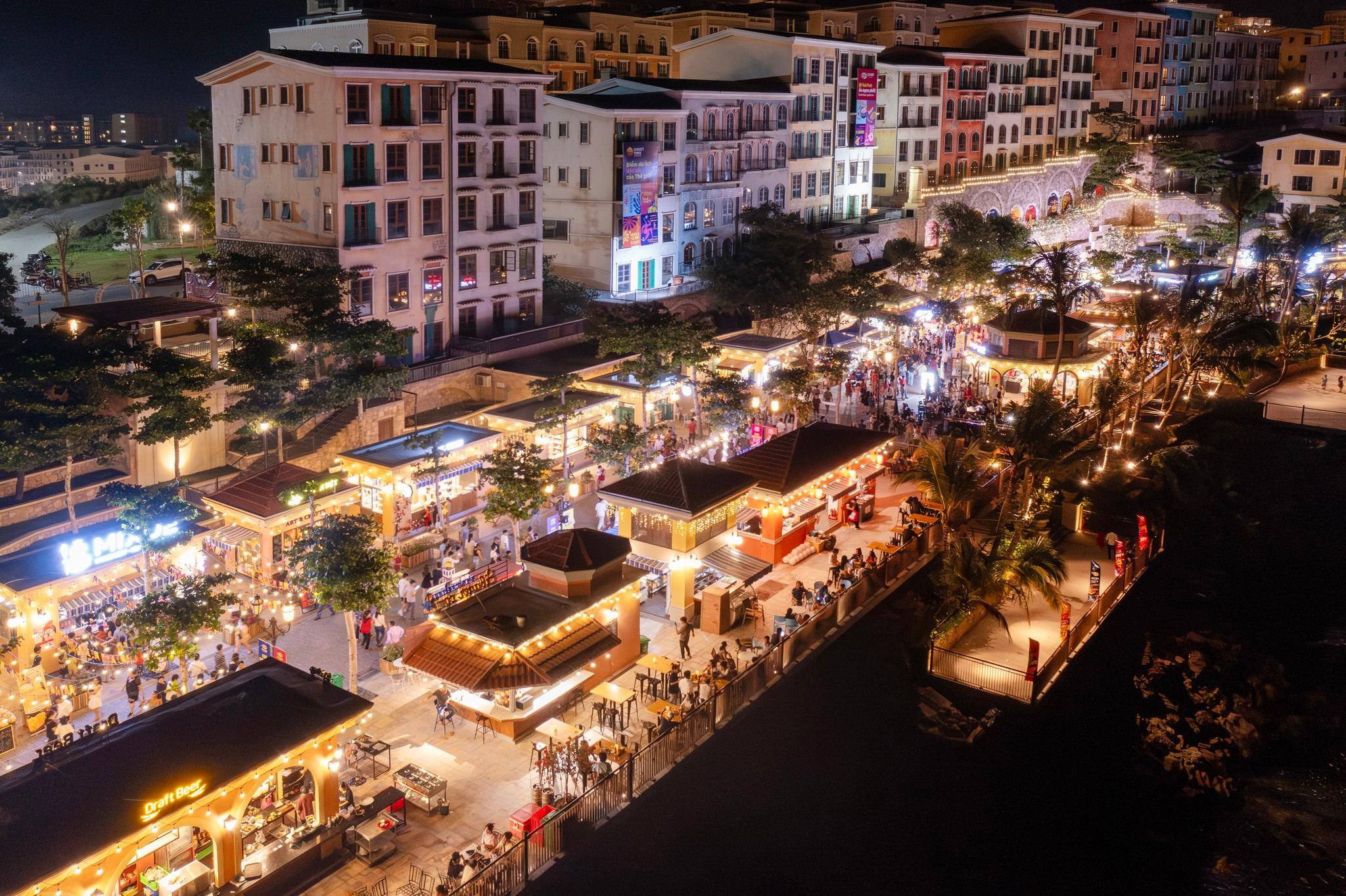 Illuminated night-market stalls beside the Sunset Town waterfront