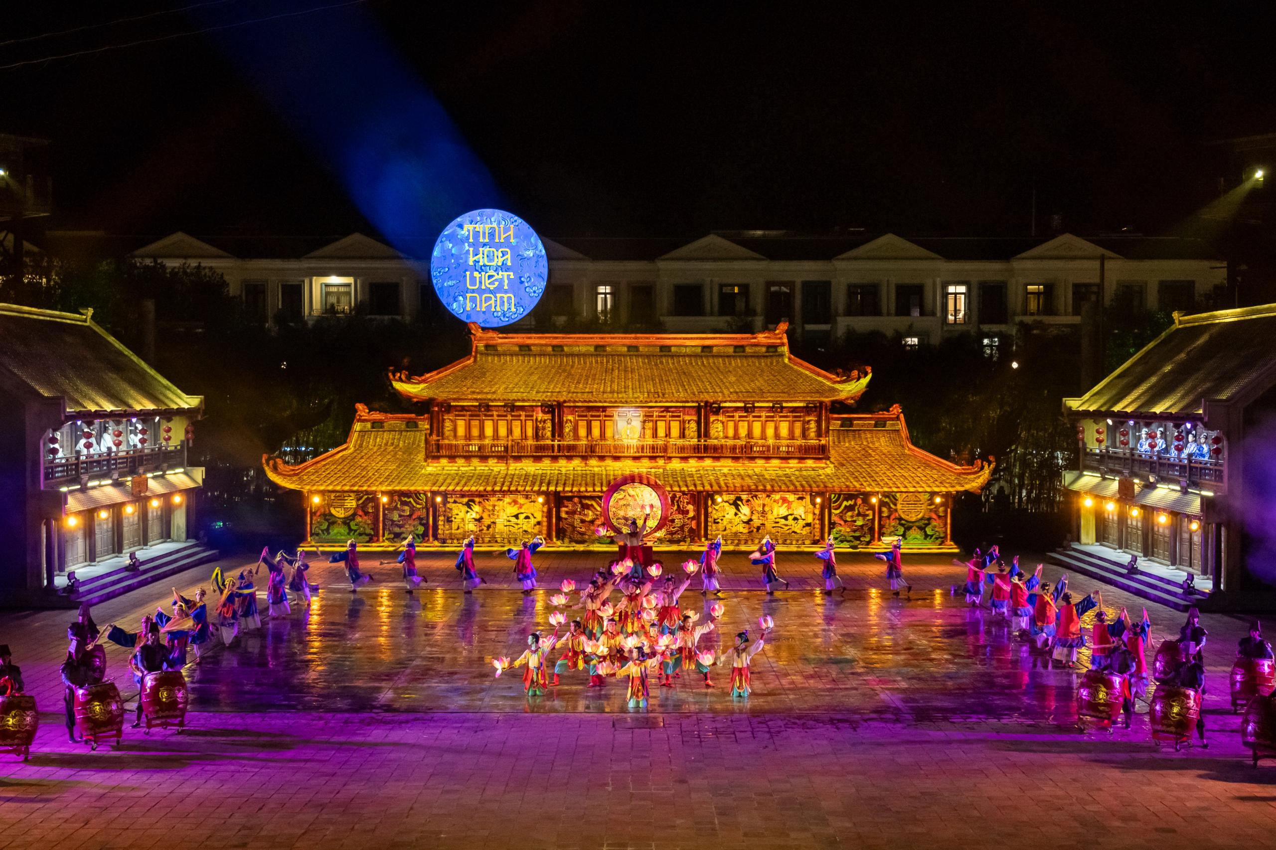 Wide view of the illuminated courtyard stage and performers