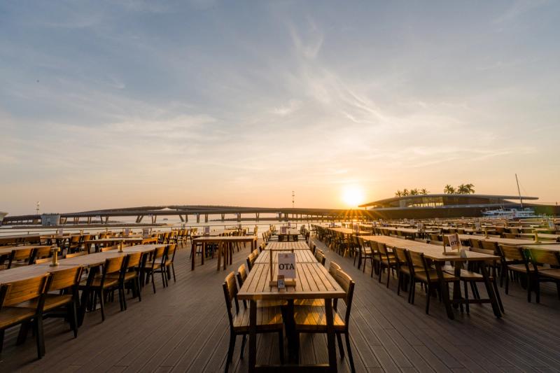 Sun Bavaria outdoor dining tables facing Kiss Bridge at sunset