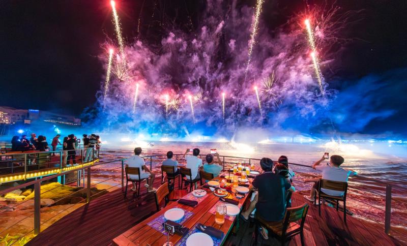 Waterfront dining tables facing fireworks