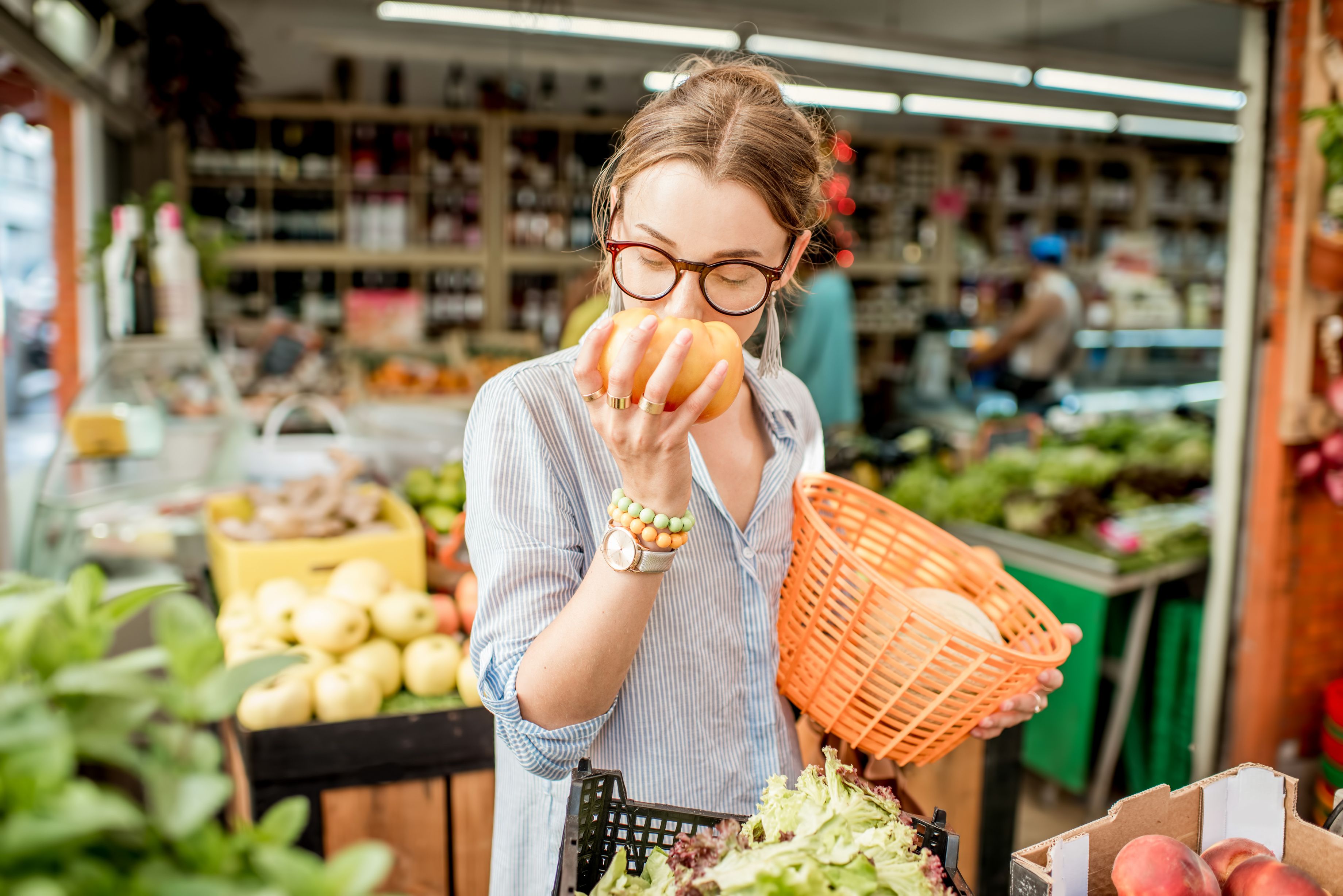 Woman smelling fruit in supermarket