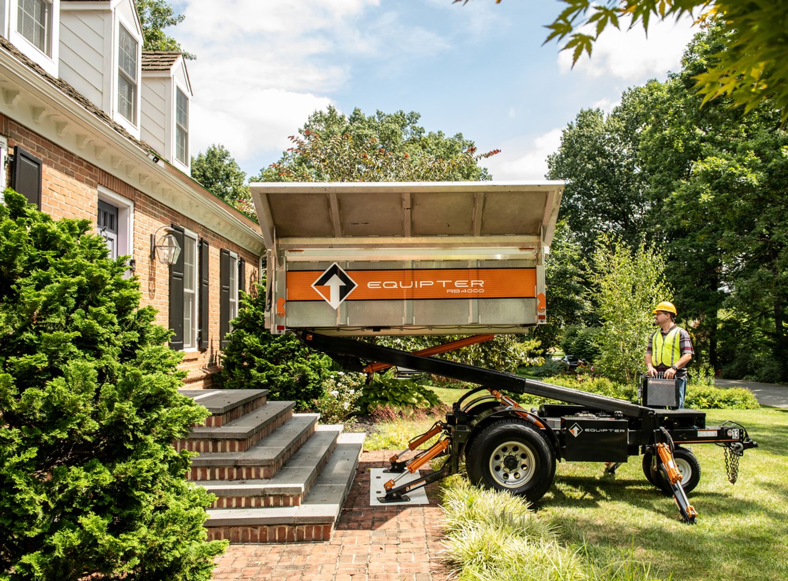 Equipter 4000 container rolled back over front steps and shrubs beside a house