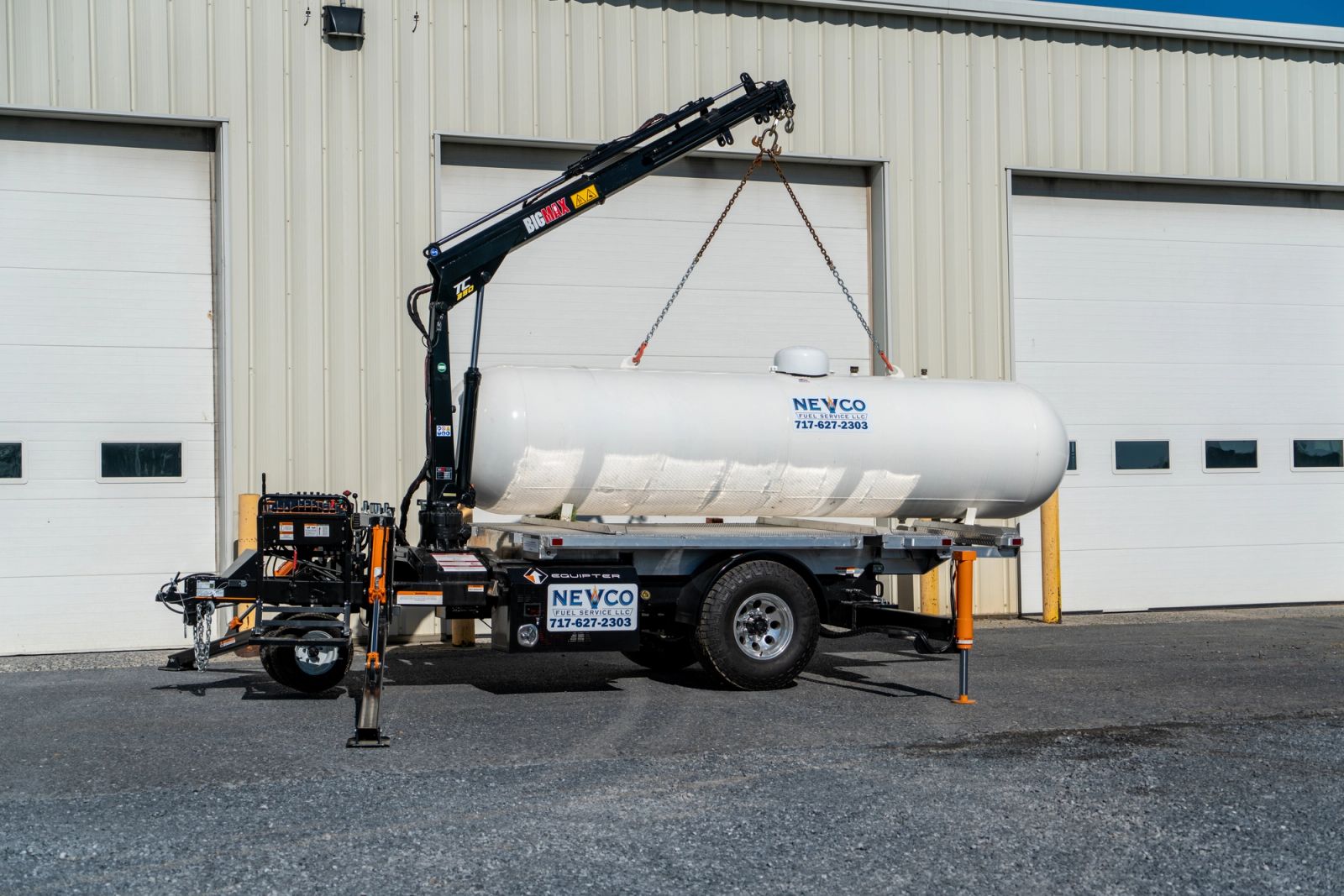 Equipter 5400 crane lifting a heavy tank off its platform with the operator at the remote