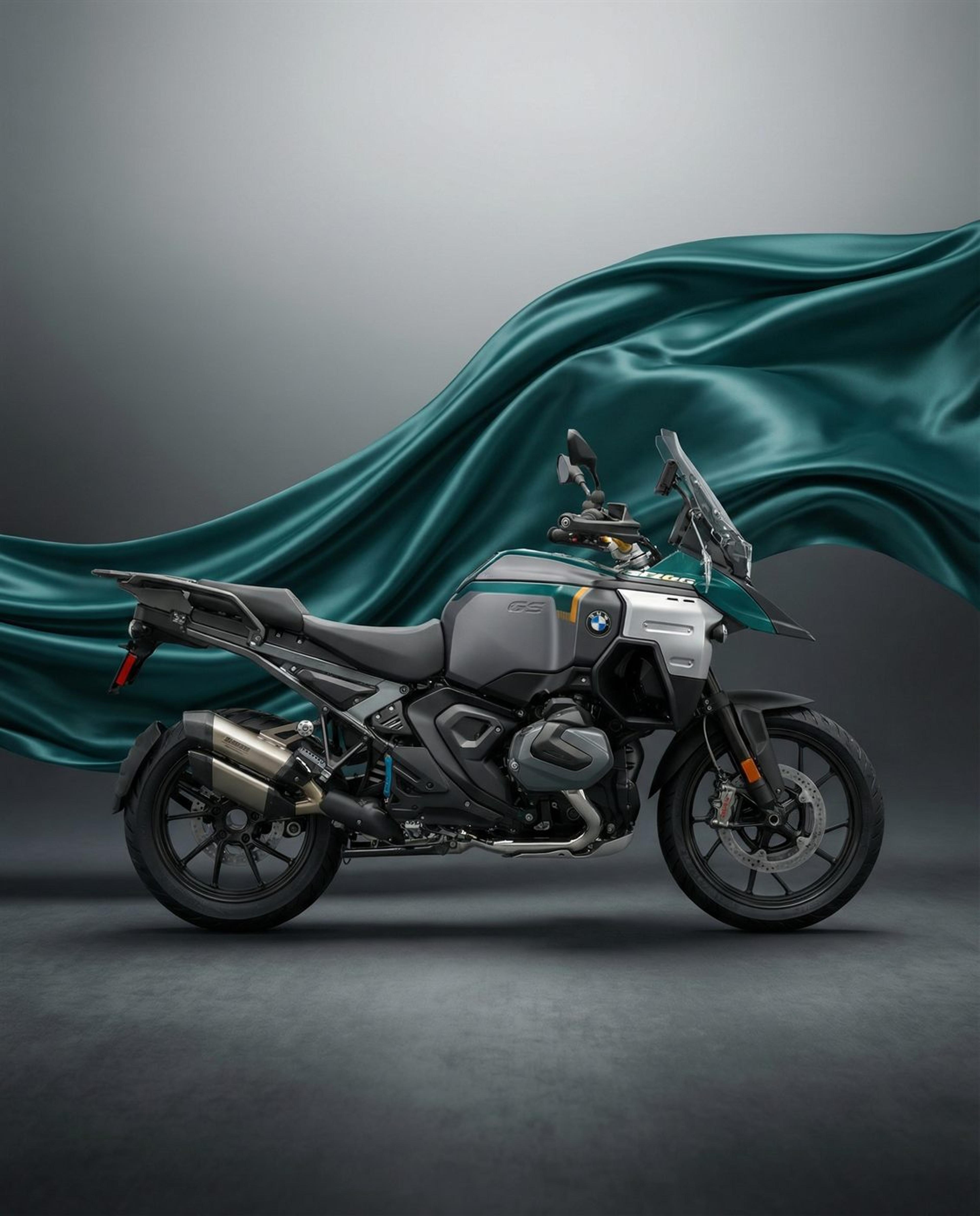BMW adventure motorcycle in a dark studio with green silk drifting across the frame