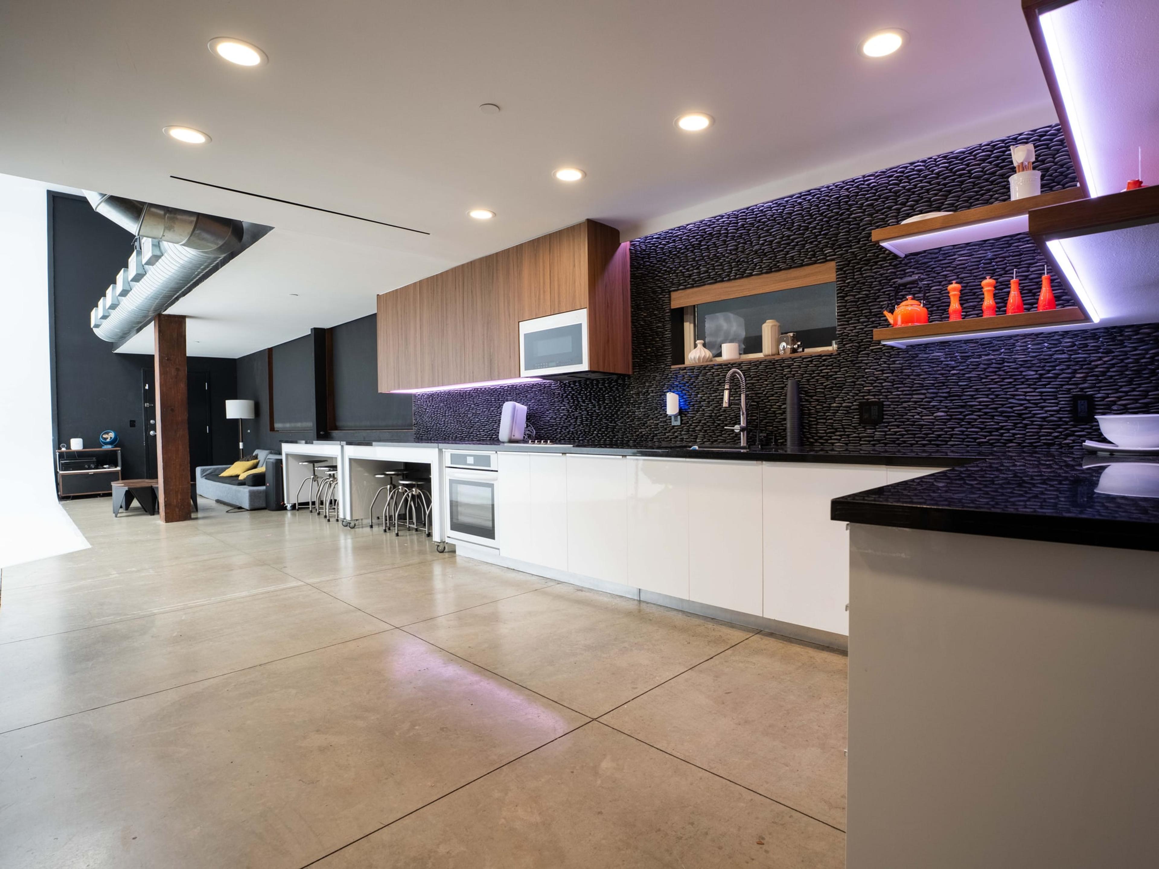 Studio kitchen and breakfast bar under violet accent lighting