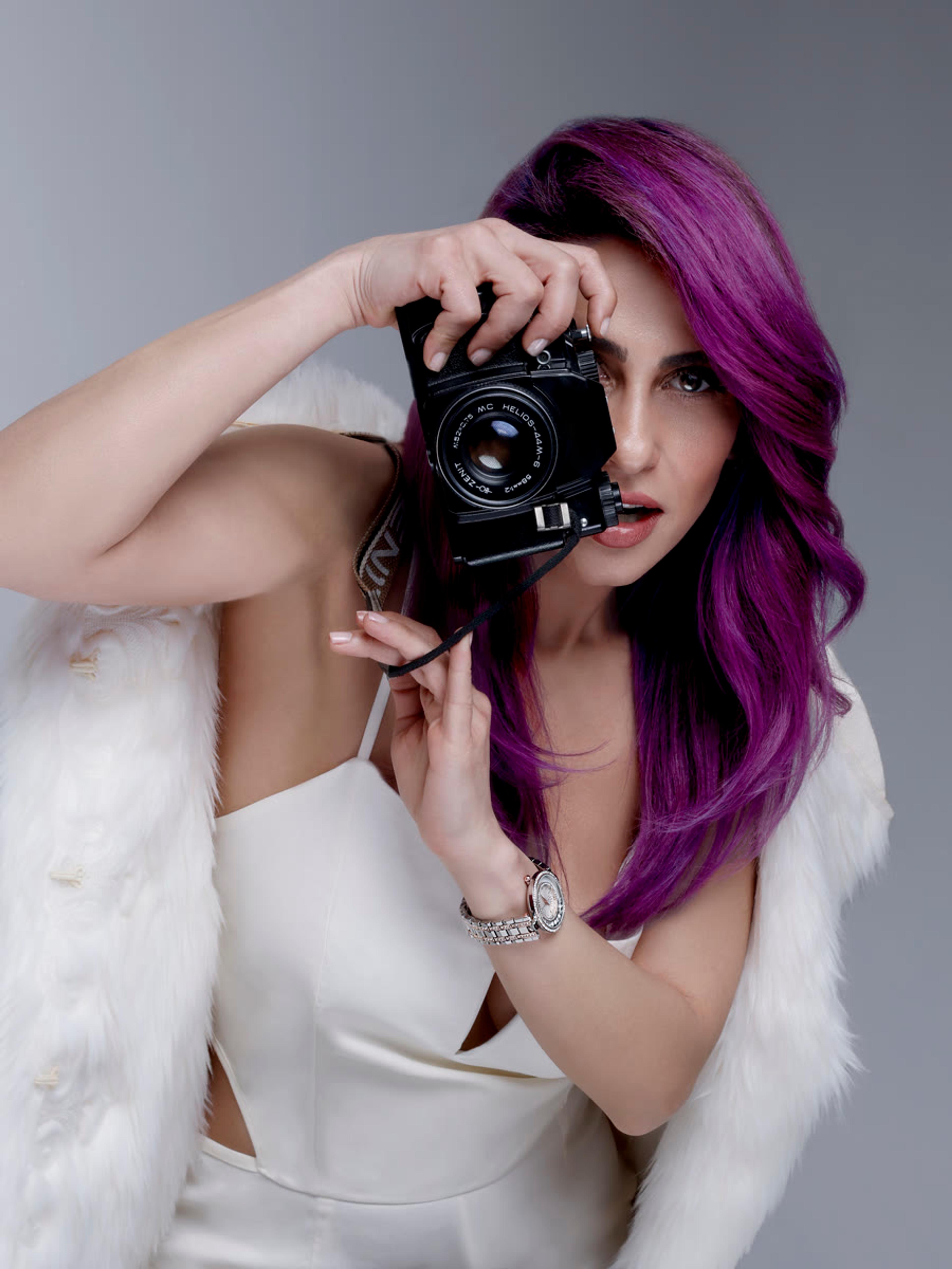 Portrait of Ghazaleh Alamshahi, founder of Hazel Production, holding a camera
