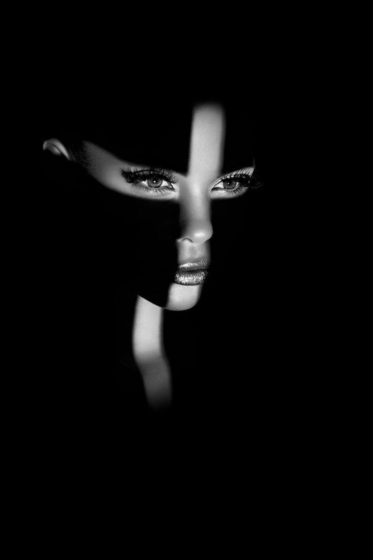 High-contrast black and white beauty portrait lit with a single hard light