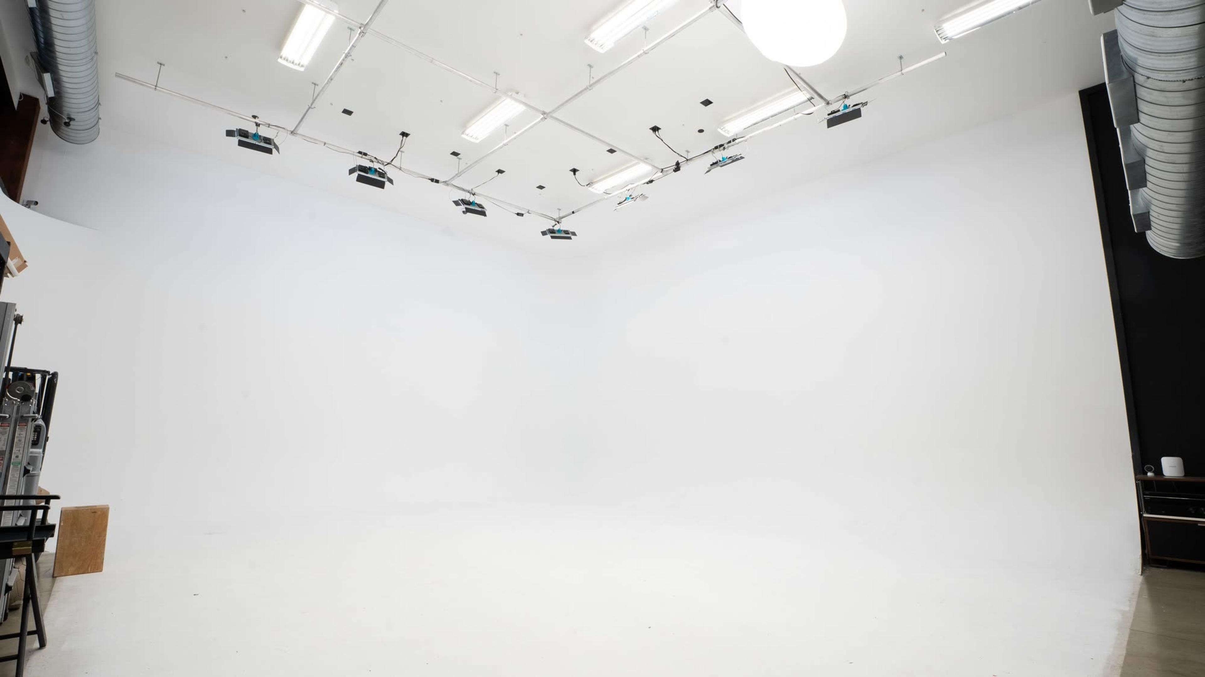 The studio's white cyclorama wall lit from an overhead grid