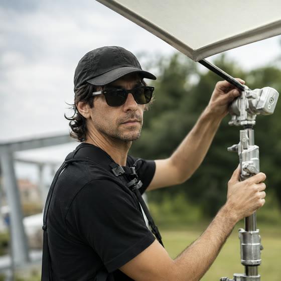 Gaffer rigging a lighting stand on an outdoor set