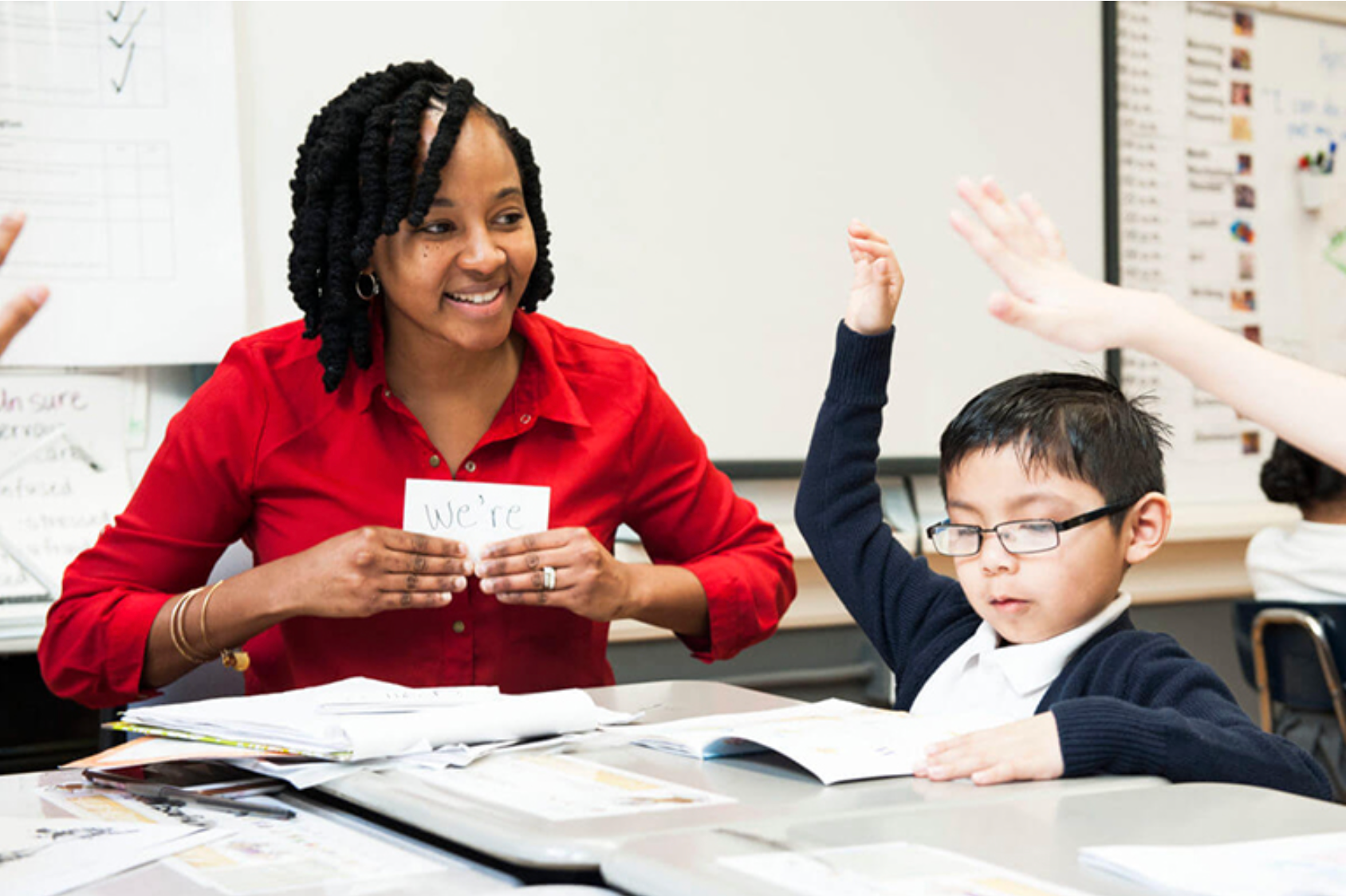 Ascend teacher with flashcards and students raising hands