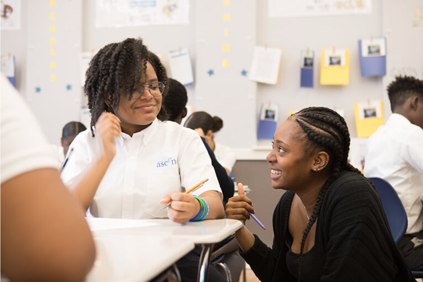 Ascend teacher leaning in with student and smiling