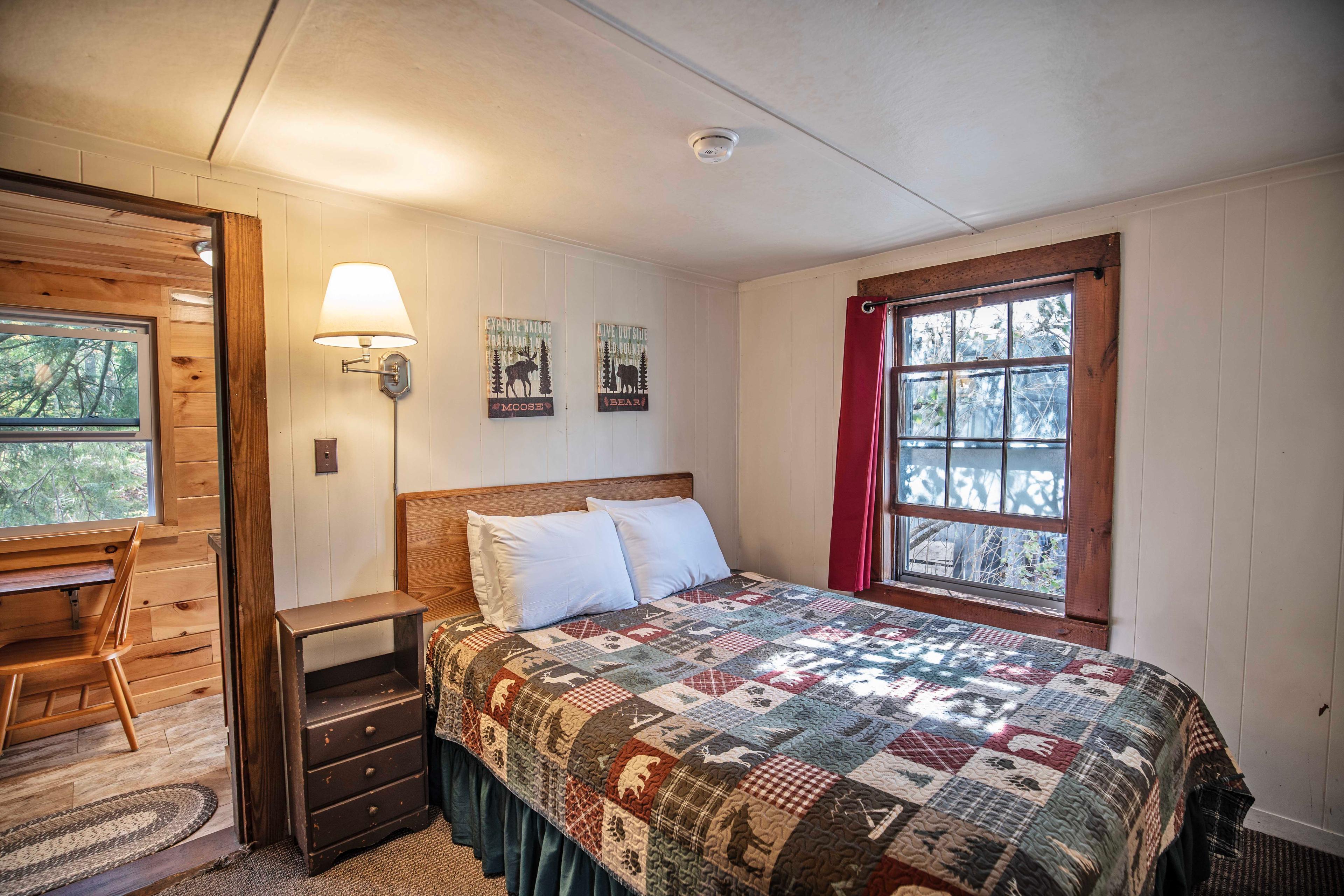 Bedroom with plush queen-sized bed in Falling Waters cabin. #ScenicViews #YearRoundComfort #VacationRental #MountainRetreat