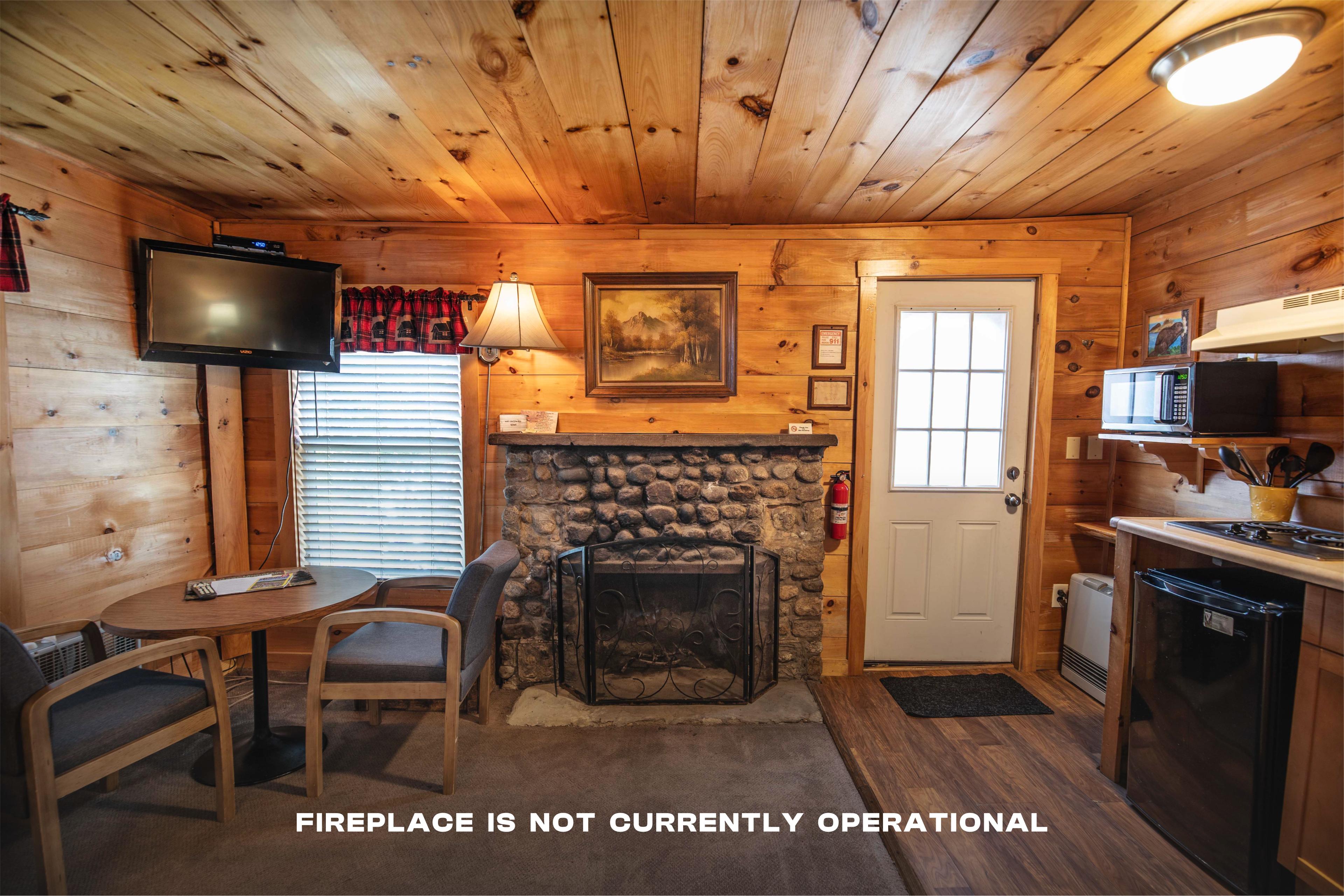 Gather around the beautiful riverstone fireplace in Beaver Pond cabin. #PeacefulRetreat #FirewoodAvailable #RomanticCabin #ScenicPorch