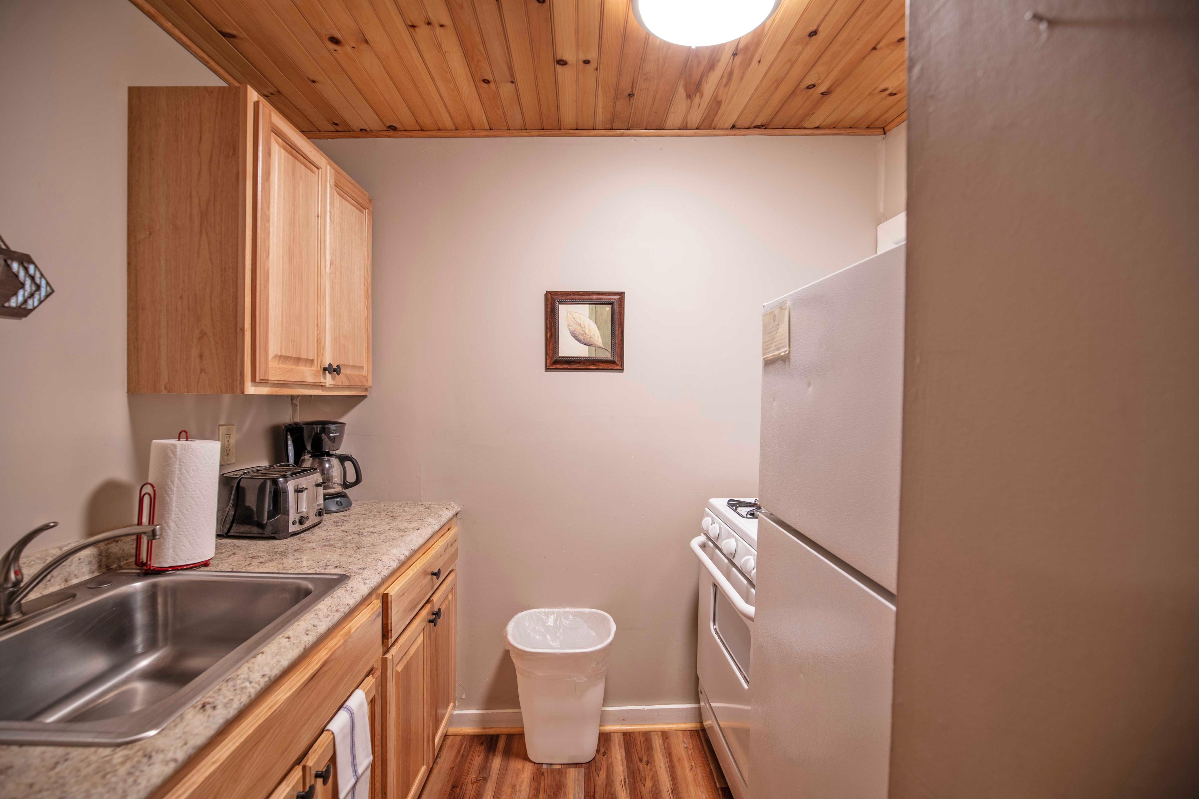 Well-equipped kitchen with mini-fridge, microwave, and stovetop at Mount Lincoln. #OutdoorDeck #PropaneGrill #KitchenAmenities #FullBathroom