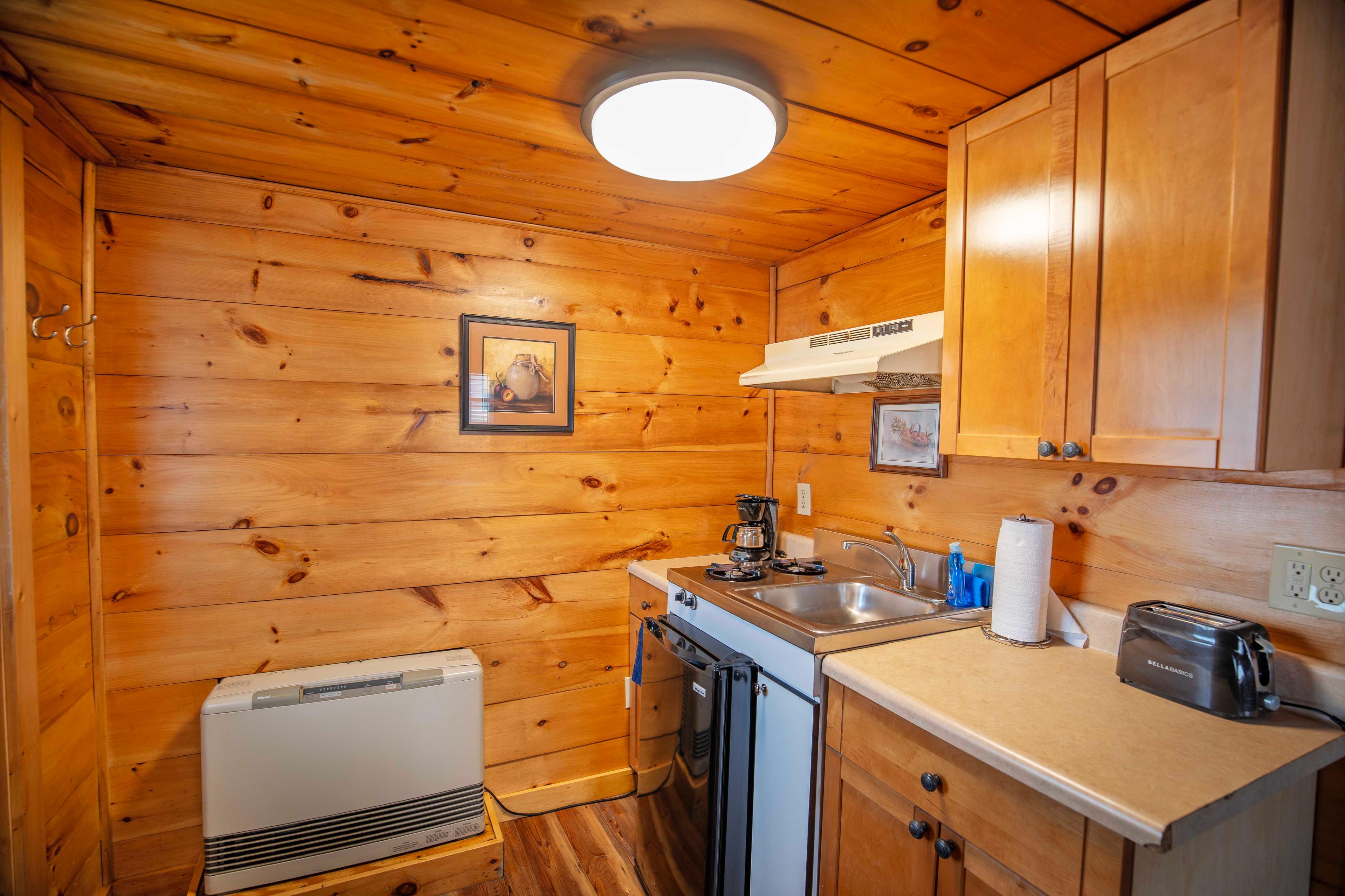 Well-equipped kitchen with mini-fridge, microwave, and stovetop at Lost River cabin. #YearRoundComfort #VacationRental #MountainRetreat #RomanticGetaway