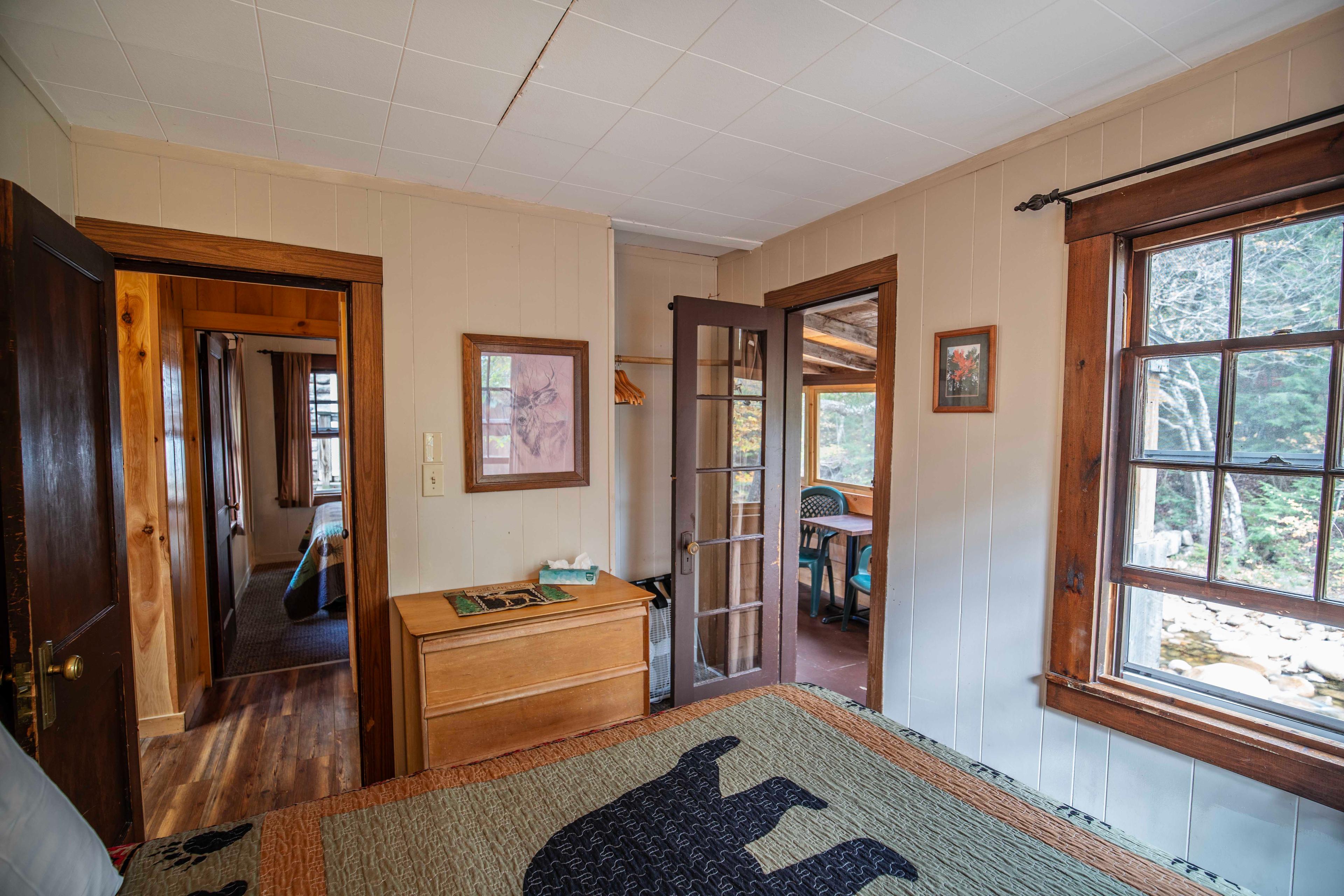 Relax on the screened-in porch of The Moose's Antler with river views. #RiverfrontCabin #LincolnNH #WhiteMountains #CabinRetreat