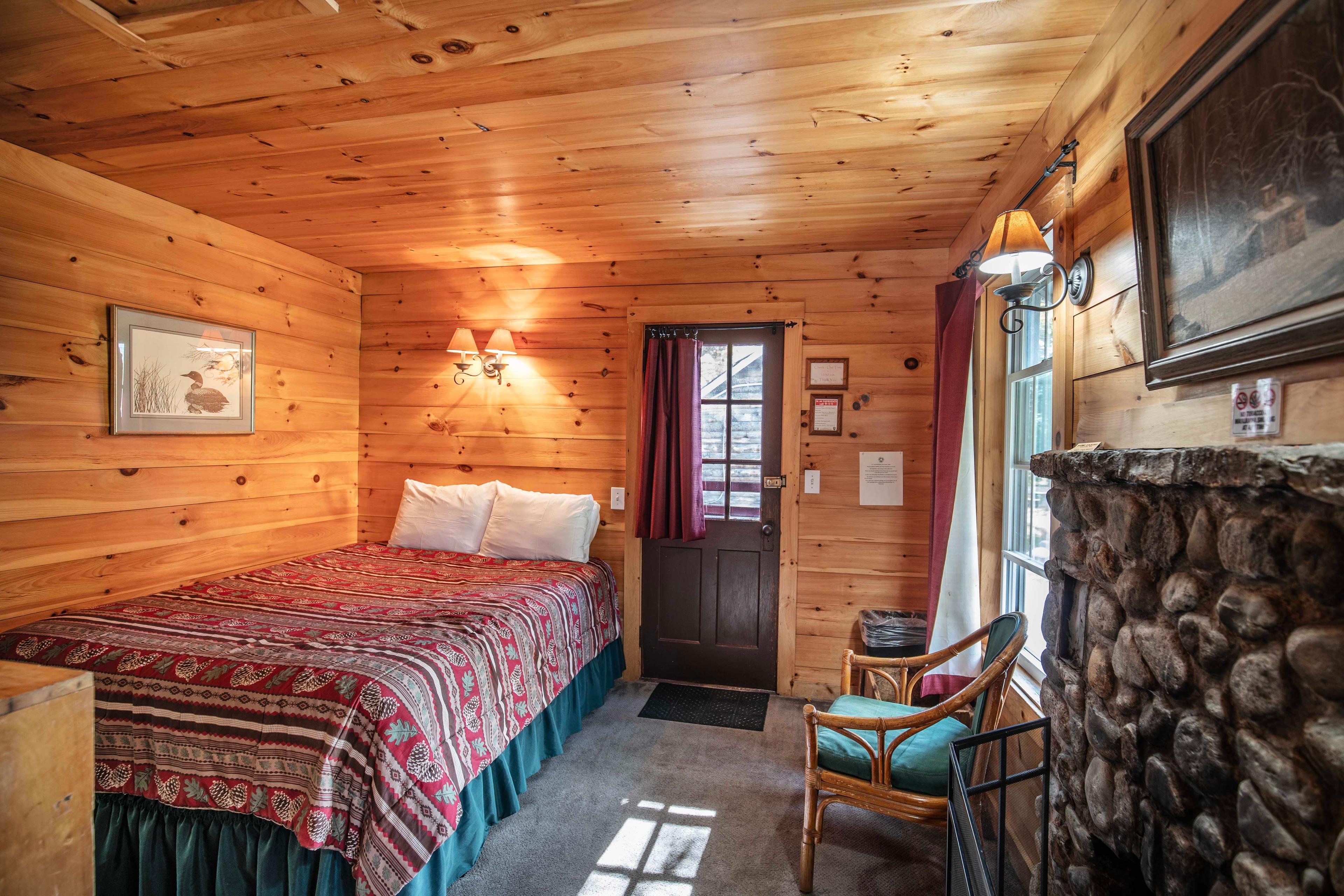 Comfortable bedroom with a plush queen-sized bed in The River Otter cabin. #YearRoundComfort #VacationRental #MountainRetreat #RomanticGetaway