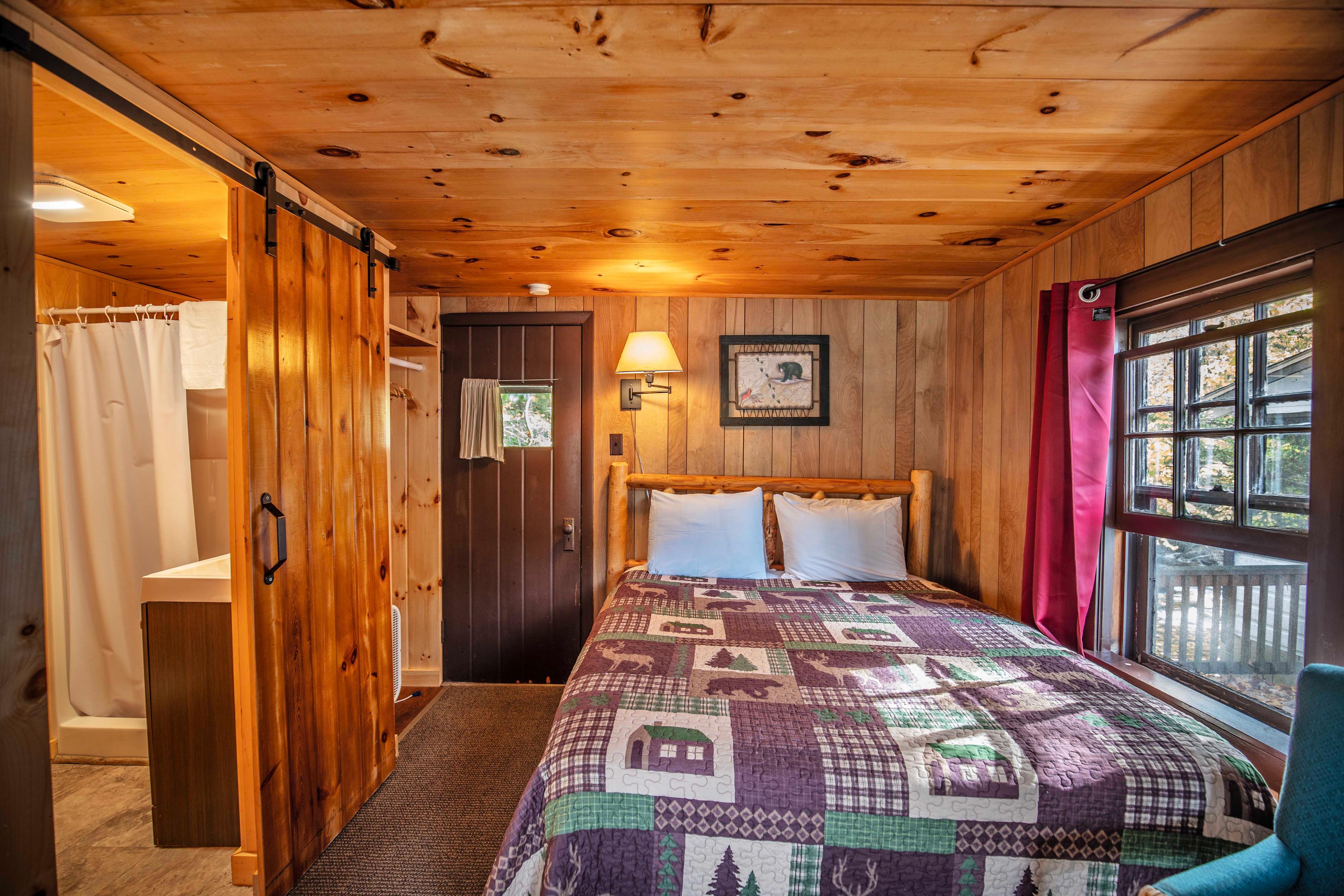 Bedroom with plush queen-sized bed at Cathedral Ledge cabin. #MorningCoffee #EveningRelaxation #ScreenedInPorch #RusticCharm