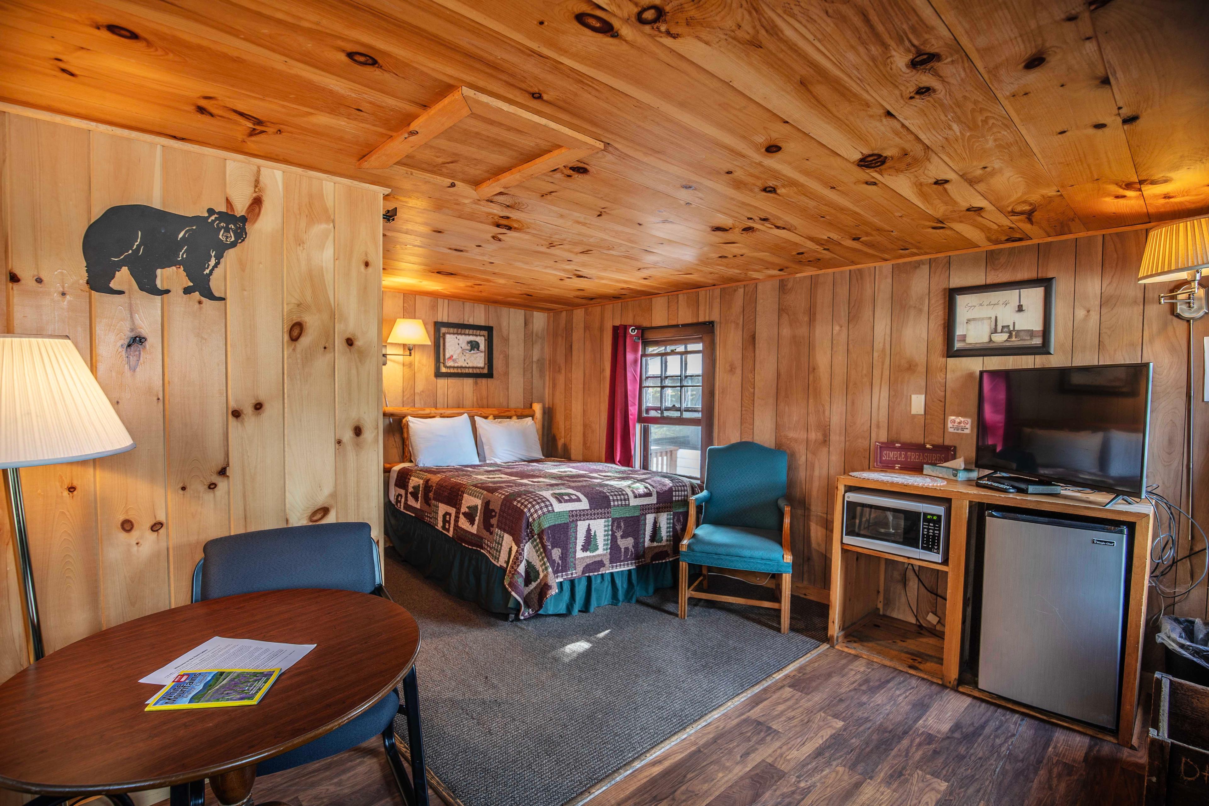 Cozy open living concept with a stone fireplace at Cathedral Ledge cabin. #LincolnNH #WhiteMountains #RomanticGetaway #CozyRetreat