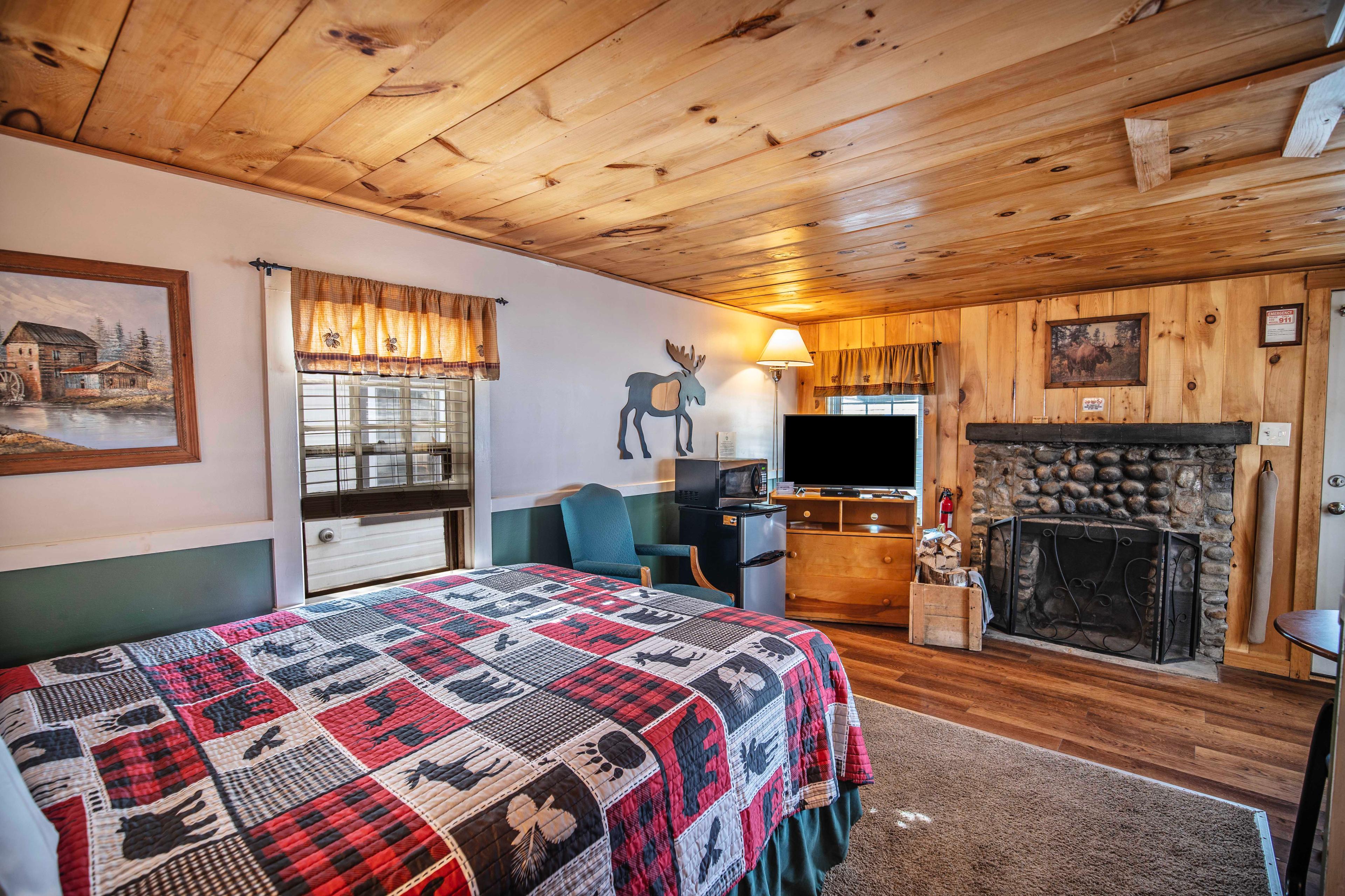 Cozy circular dining table and TV area next to fireplace in The Basin cabin. #WhiteMountains #CabinRetreat #NatureEscape #CozyCabin