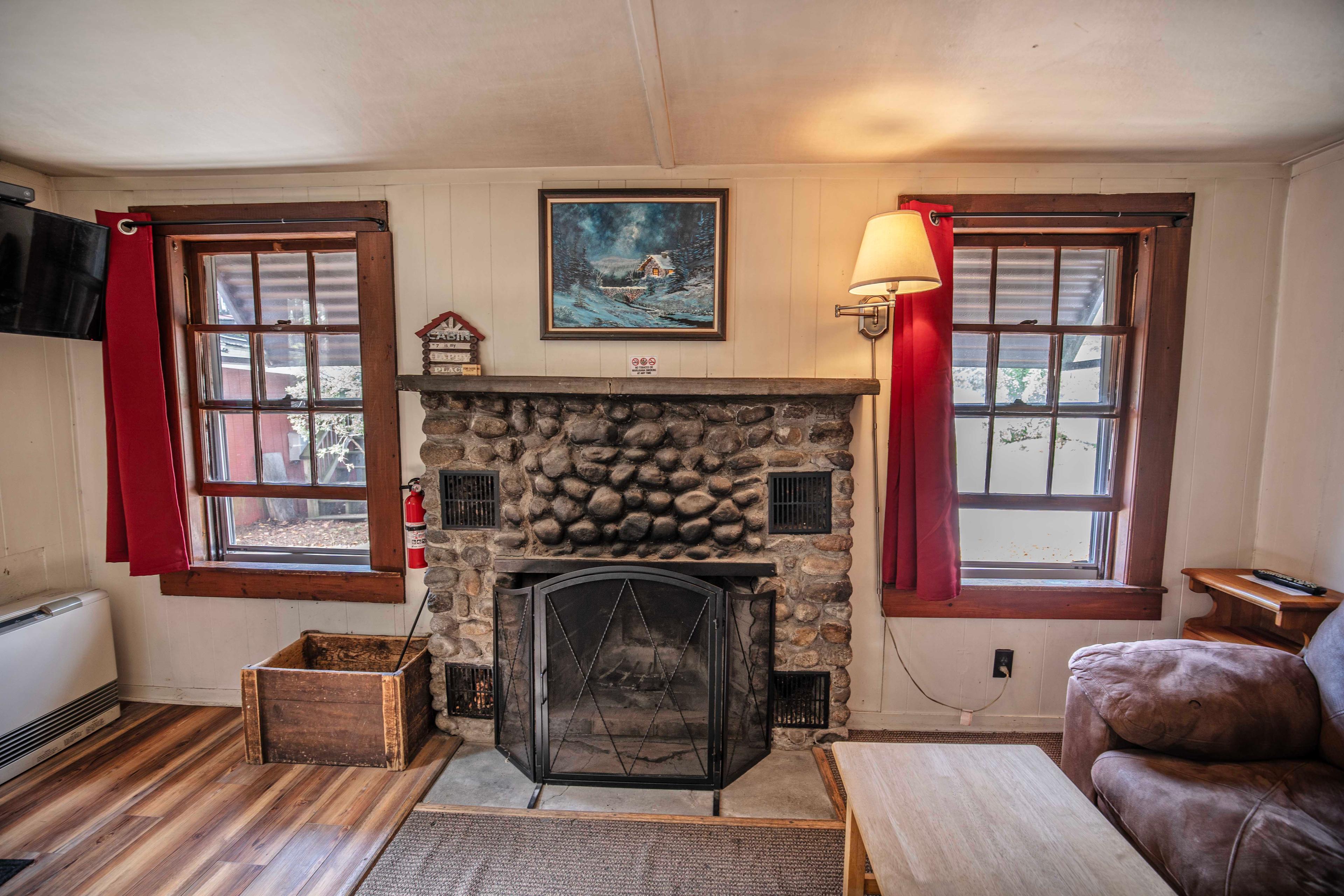 Stunning riverstone fireplace and mantle in Falling Waters cabin. #FireplaceNights #RusticCharm #NatureLovers #CabinGetaway