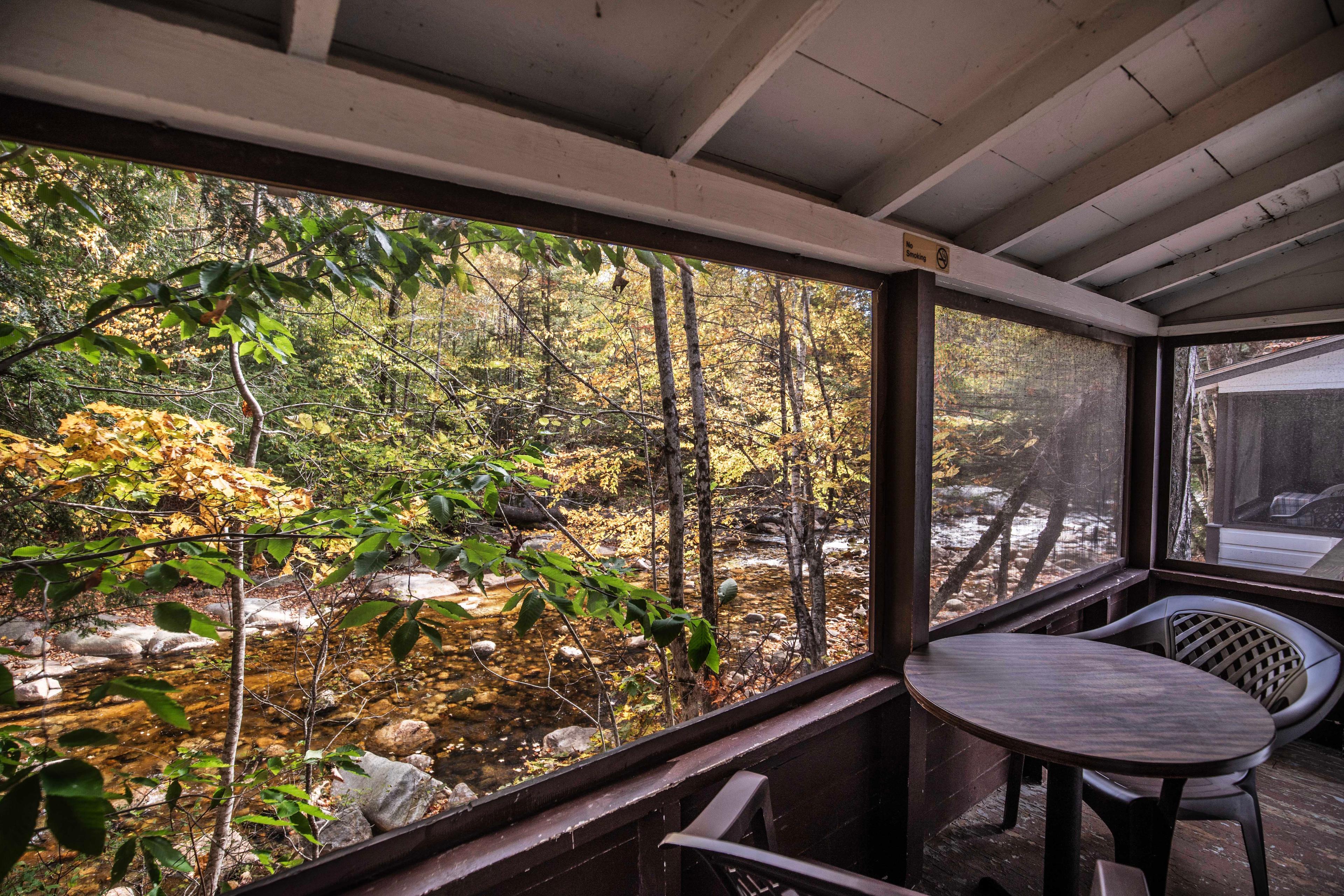 Outdoor relaxation on the porch of Cathedral Ledge cabin. #MorningCoffee #EveningRelaxation #ScreenedInPorch #RusticCharm