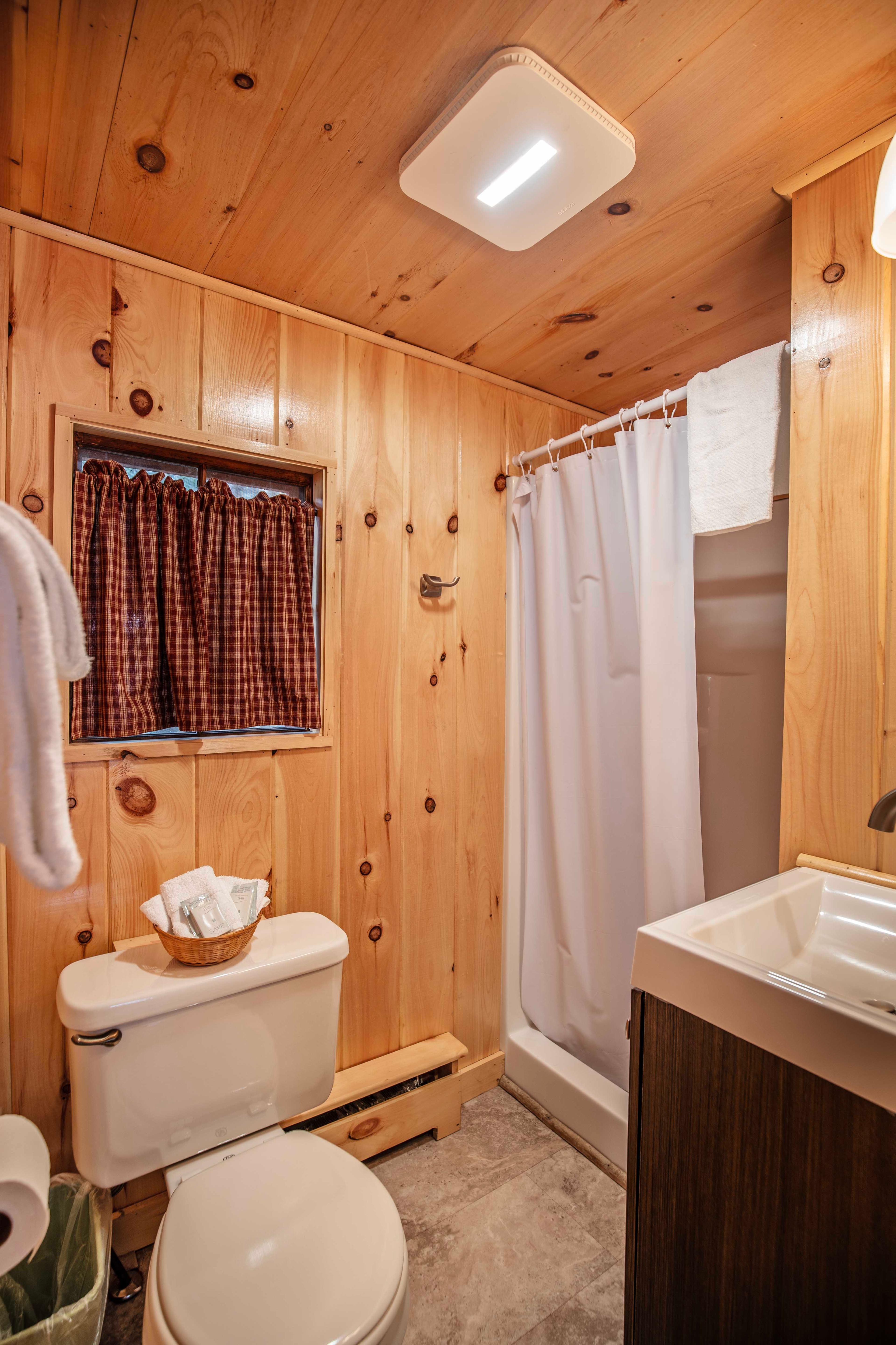 Full bathroom with stand-up shower adjacent to the bedroom in Cathedral Ledge cabin. #CabinVacation #HiddenGem #EscapeTheCity #PeacefulRetreat