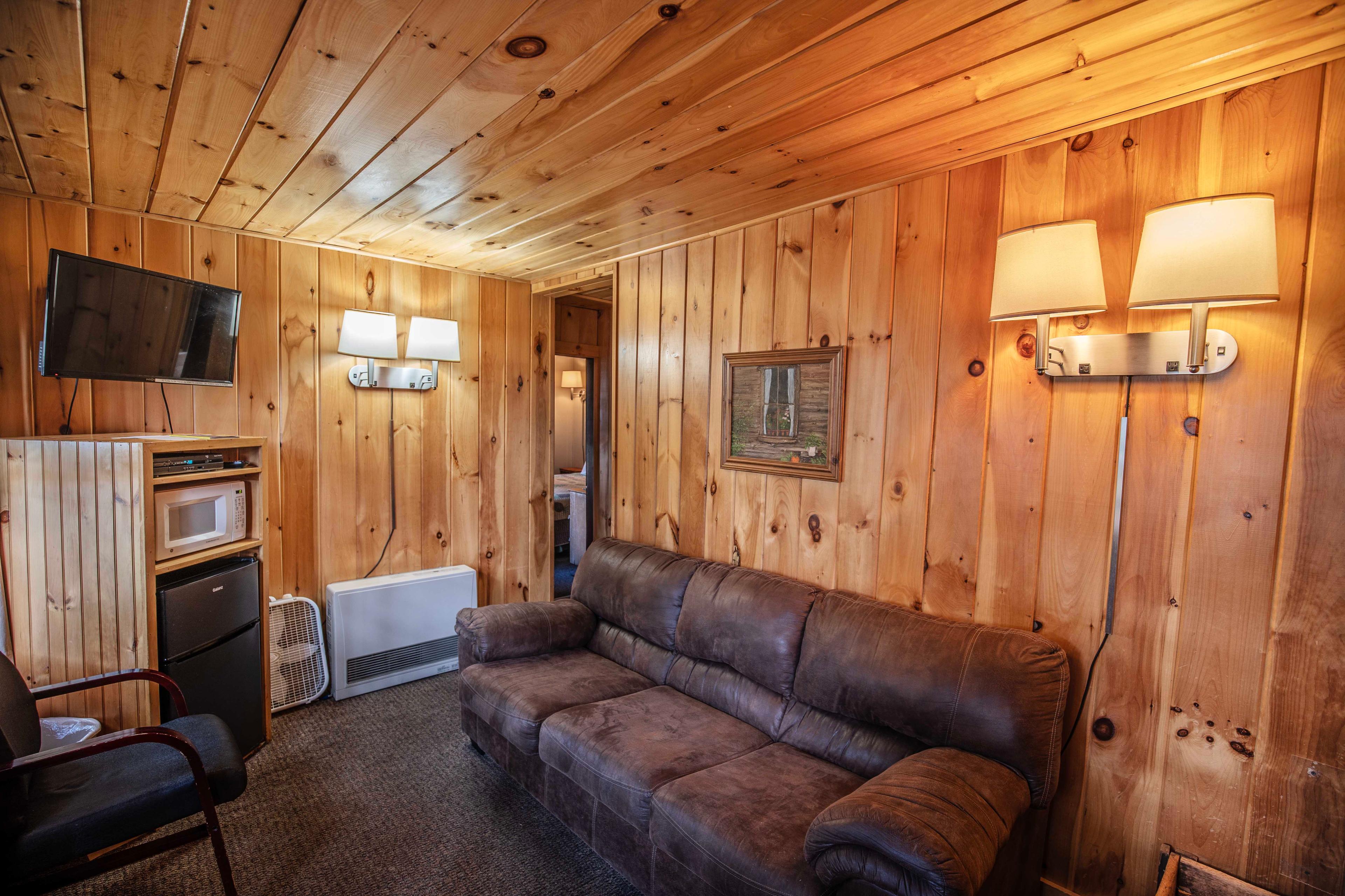 Riverstone fireplace in the living room of The Moose's Antler. #RusticCharm #CozyCabin #WoodBurningFireplace #NatureLovers