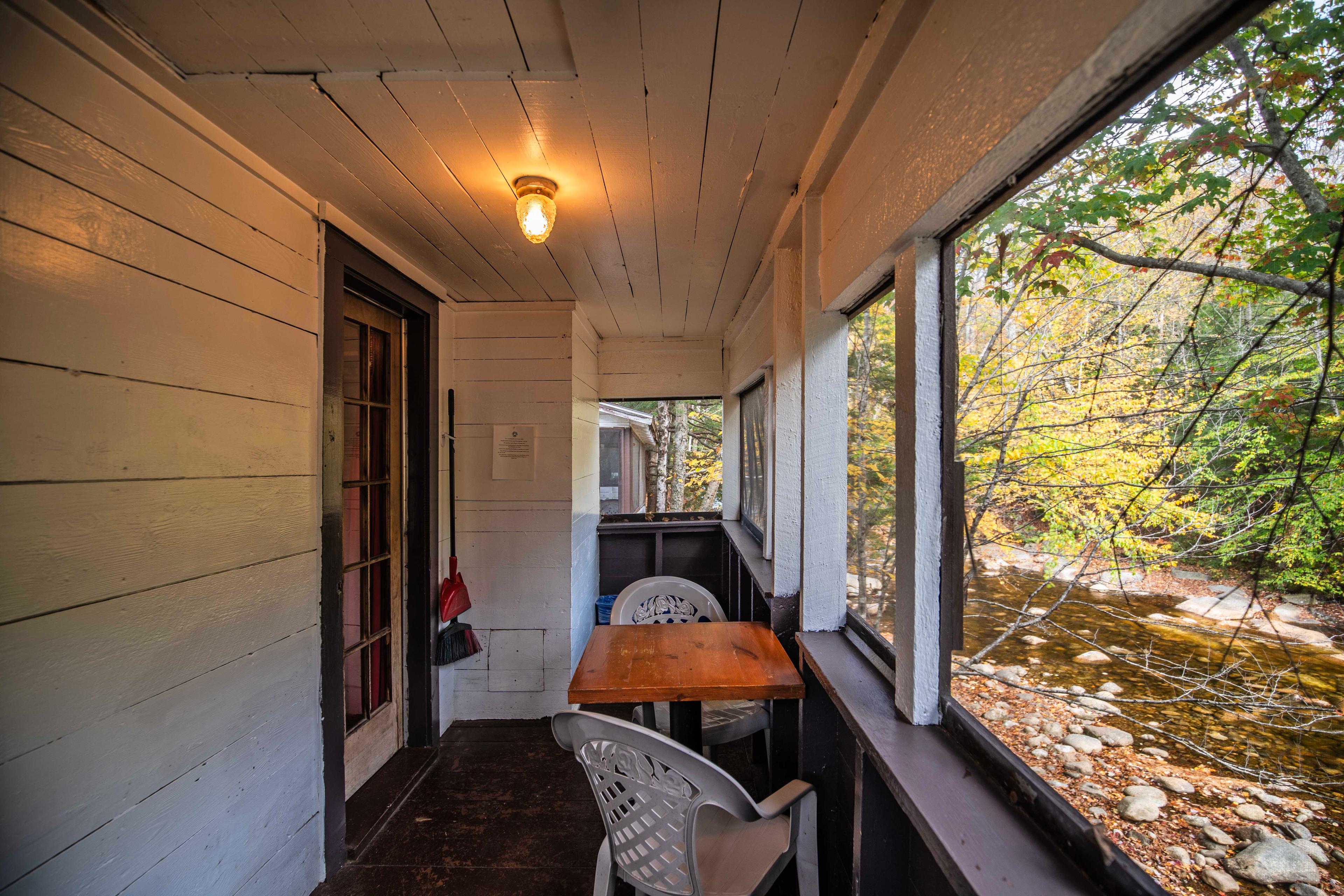 Outdoor relaxation on the porch of Lost River cabin. #OutdoorDining #MorningCoffee #EveningRelaxation #ScreenedInPorch