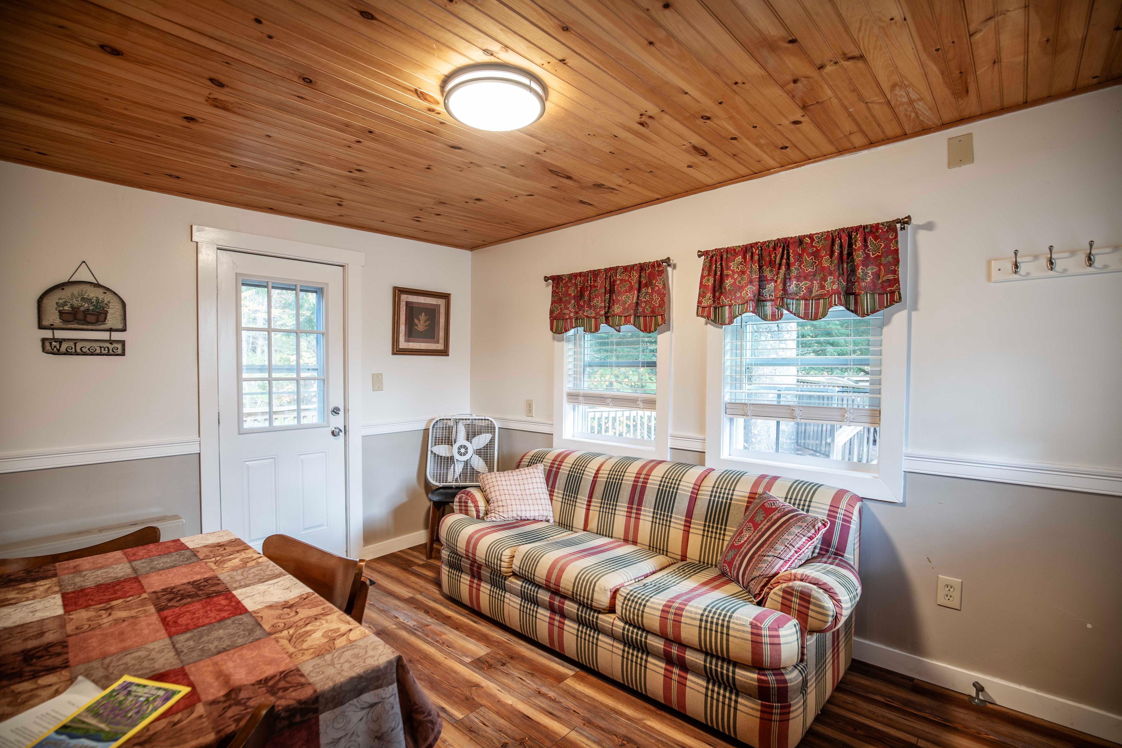 Cozy living room with comfortable couch and dining area at Mount Lincoln cabin. #KitchenAmenities #FullBathroom #FrontPorch #YearRoundComfort