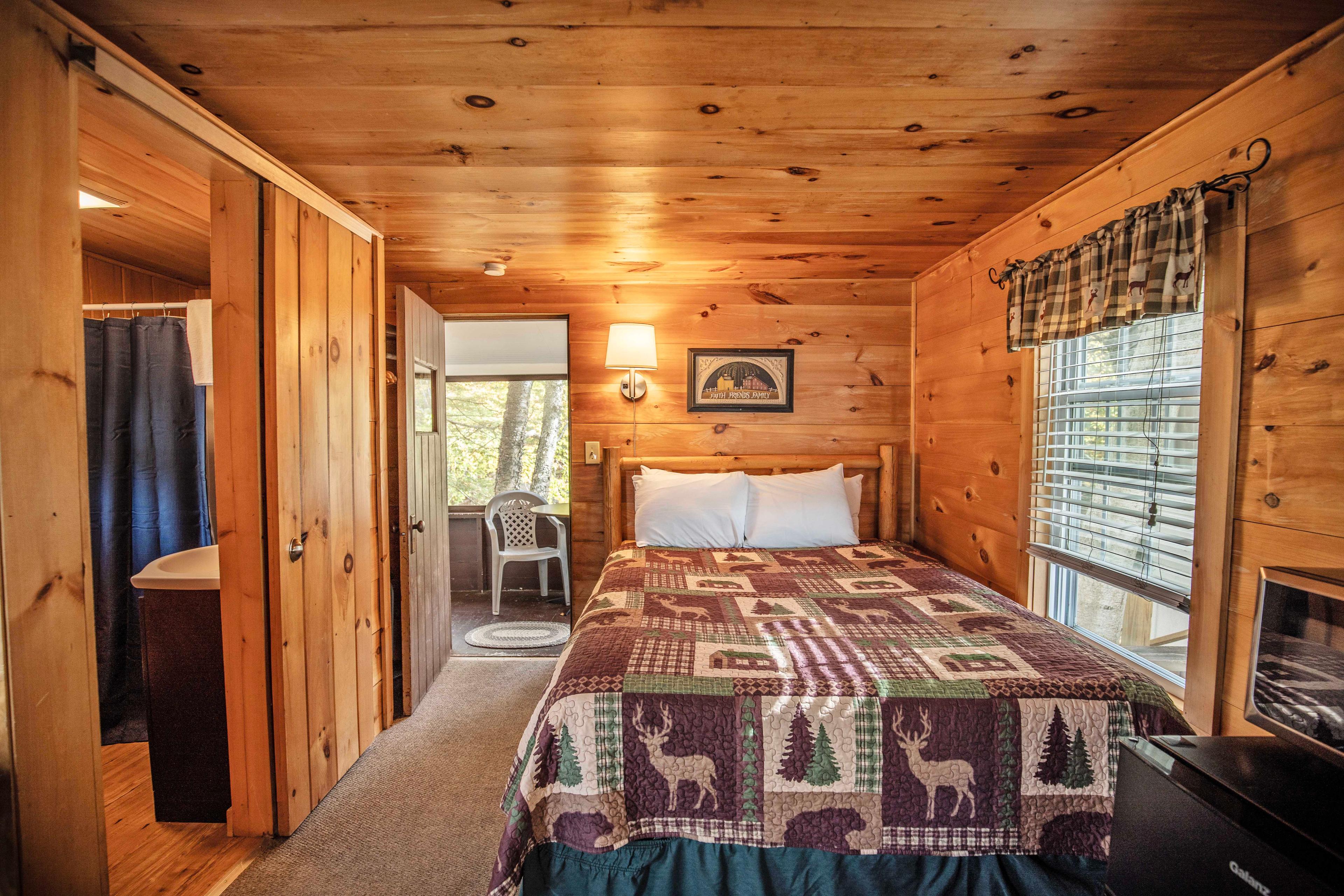 Bedroom with plush queen-sized bed at The Flume cabin. #CabinGetaway #ScenicViews #YearRoundComfort #VacationRental