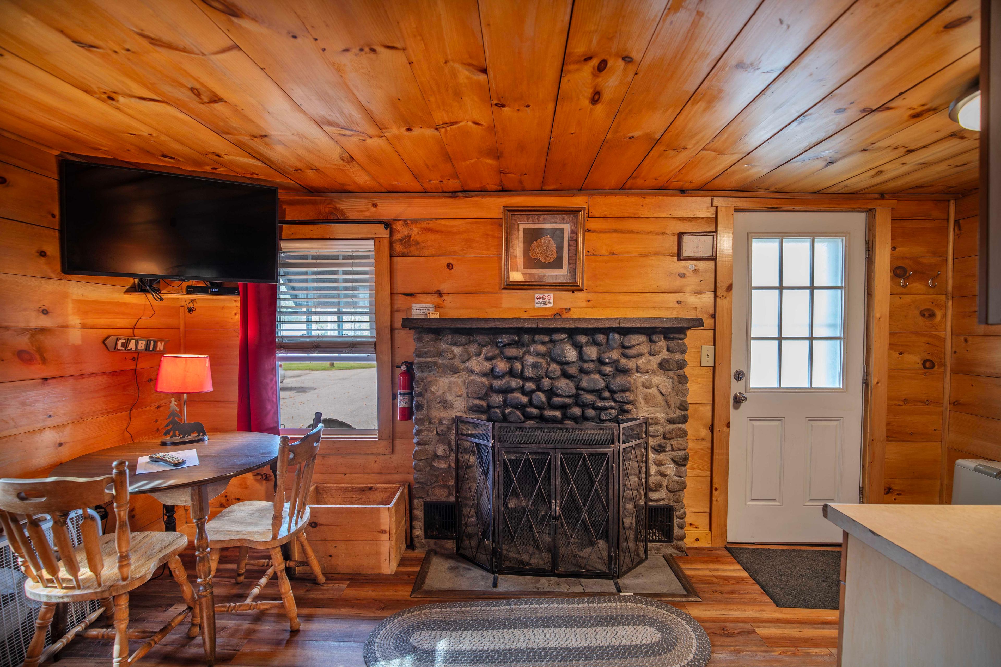 Cozy up by the riverstone fireplace with mantle in Lost River cabin. #MountainViews #TravelNH #WoodBurningFireplace #RusticMeetsModern